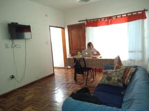 a woman sitting at a table with a laptop in a living room at HA! 2 Resi para estudiantes in Córdoba