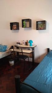 Zimmer mit einem Tisch, einem Bett und einem Schreibtisch in der Unterkunft HA! 2 Resi para estudiantes in Cordoba