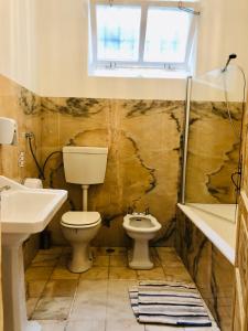 ein Badezimmer mit Toilette, Waschbecken und Badewanne in der Unterkunft Lanui Vintage Guest House in Sintra + 69 Fotos