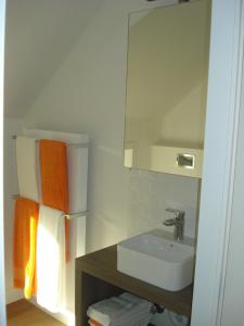 a white bathroom with a sink and a mirror at Hoeve De Hagepoorter in Jabbeke