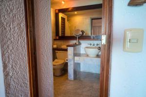 a bathroom with a toilet, sink and mirror at Casa de los Sueños Hotel Boutique in Isla Mujeres
