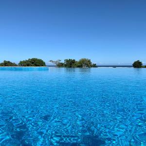 Yadua Bay Resort & Villas في Yandua: جسم كبير من الماء الأزرق مع الأشجار في الخلفية