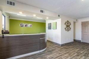 un vestíbulo con un mostrador y una pared verde en Extended Stay Pensacola en Pensacola
