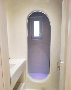 an arched door in a bathroom with a window at Kritamos suites in Irakleia