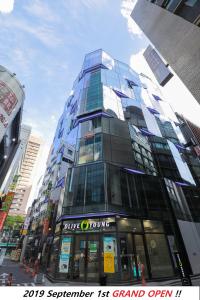 a tall glass building in the middle of a city at Line Hotel Myeongdong in Seoul