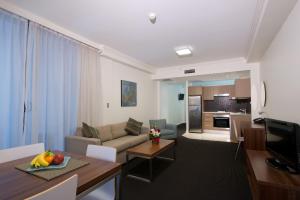 ein Wohnzimmer mit einem Sofa und einem Tisch in der Unterkunft APX World Square in Sydney