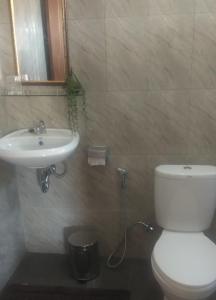 a bathroom with a white toilet and a sink at Serongga guest house in Lebih