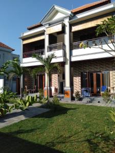 a large building with palm trees in front of it at Purnama 2 Homestay in Canggu