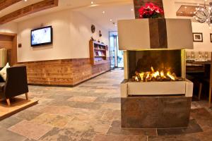 a fireplace in a living room with a tv at AlpinApart Bacher in Serfaus