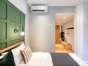 een slaapkamer met een bed en een groene muur bij Habyt Cantonment - formerly Hmlet Cantonment in Singapore