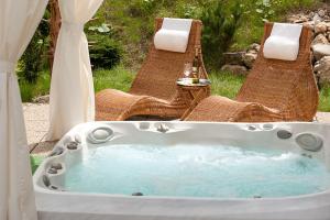 a jacuzzi tub with a table and two chairs at Apartmany Hrabovo in Ružomberok