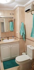 łazienka z umywalką, toaletą i lustrem w obiekcie Apartment Campoamor Descansa w mieście Campoamor
