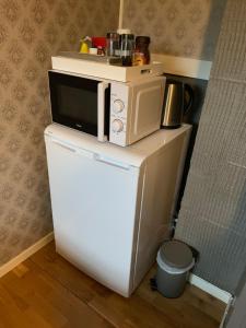 um micro-ondas sentado em cima de um frigorífico em Cozy & private room in the middle of Lofoten em Leknes