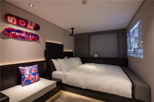 a small bedroom with a bed and a screen at Fenk Attitude Hotel Guangzhou Railway Station in Guangzhou