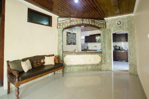 a living room with a couch and a bath tub at Blanjong Homestay by ecommerceloka in Sanur