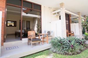 a patio with chairs and a table on a house at Blanjong Homestay by ecommerceloka in Sanur