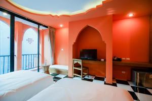 a hotel room with two beds and a tv at Khaleej Mass Hotel Patong in Patong Beach