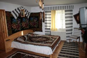 a bedroom with a bed and a window at Pensiunea Casa Alex in Sadova