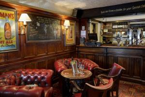a bar with leather furniture and a table and chairs at The Vine Hotel, Skegness in Skegness