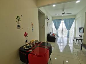 uma sala de estar com uma mesa vermelha e um sofá em Taiping Centre Point Suite 9 by BWC em Taiping