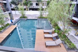 een uitzicht op een zwembad met 2 ligstoelen en sidx sidx bij Serio Condo in Bangkok