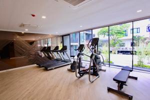 een fitnessruimte met loopbanden en crosstrainers in een gebouw bij Serio Condo in Bangkok