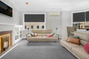 a living room with two couches and a fireplace at Horse and Jockey Hotel Homebush in Sydney