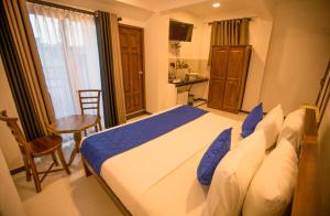 1 dormitorio con cama, mesa y ventana en Opulence Colombo, en Colombo