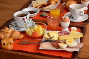 ein Tablett mit Frühstückslebensmitteln und Kaffee auf dem Tisch in der Unterkunft Hotel Le Beau Site in Saint-Pierre-de-Chartreuse