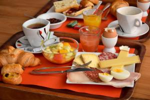 een dienblad met ontbijtproducten en koffie op een tafel bij Hotel Le Beau Site in Saint-Pierre-de-Chartreuse
