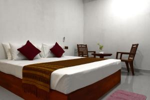 a bedroom with a large bed with red pillows at Villa77 in Polonnaruwa