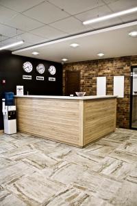 a lobby with a counter and clocks on the wall at Hotel Vzlet in Orenburg