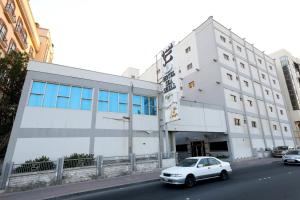 un coche blanco estacionado frente a un edificio en Sea Shell Hotel, en Manama