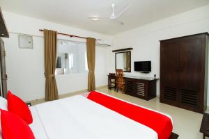 a bedroom with a red bed and a television at Hotel Nelly Marine in Colombo