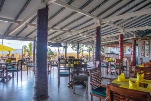 a restaurant with wooden chairs and tables and tablesktop at Happy Banana Hotel in Unawatuna