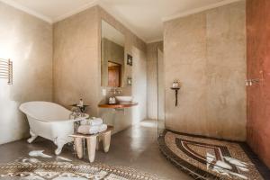 a bathroom with a bath tub and a sink at Singa Lodge - Lion Roars Hotels & Lodges in Port Elizabeth