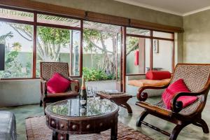 a living room with two chairs and a table at Singa Lodge - Lion Roars Hotels & Lodges in Port Elizabeth