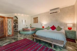 a bedroom with a bed and a bench and a tub at Singa Lodge - Lion Roars Hotels & Lodges in Port Elizabeth