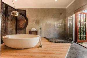 a large bathroom with a tub and a shower at Singa Lodge - Lion Roars Hotels & Lodges in Port Elizabeth