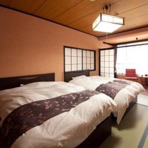 a bedroom with two beds and a window at caffel Hina-no-sato in Hita