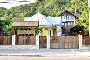 a wooden fence in front of a house at Căsuța de Poveste in Târgu Neamț