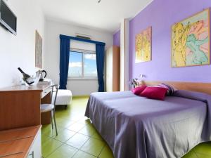 um quarto com uma cama, uma secretária e uma janela em Alta Marea Sorrento em Massa Lubrense