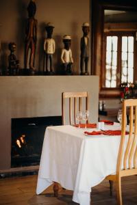 a table with wine glasses on it with a fireplace at Singa Lodge - Lion Roars Hotels & Lodges in Port Elizabeth