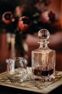 a glass bottle and a glass cup on a table at Singa Lodge - Lion Roars Hotels & Lodges in Port Elizabeth