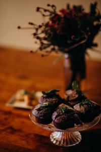 a plate of chocolate muffins on a table with a vase at Singa Lodge - Lion Roars Hotels & Lodges in Port Elizabeth