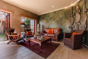 a living room filled with furniture and a fireplace at Singa Lodge - Lion Roars Hotels & Lodges in Port Elizabeth