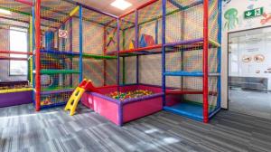 a play room with a playground with a slide and a play structure at Apartament Siesta Sunny Spa in Kołobrzeg +28 photos