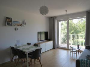 a living room with a table and chairs and a television at Apartament Siesta Sunny Spa in Kołobrzeg