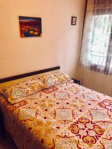 カラフェルにあるPlaya y Montaña en Calafellのベッドルーム1室(花の咲く毛布付きのベッド1台付)