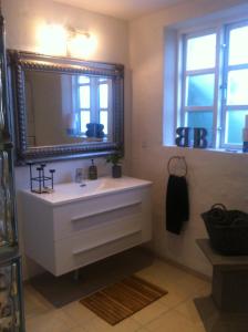 a bathroom with a white sink and a mirror at Vejle Golf Apartments in Børkop